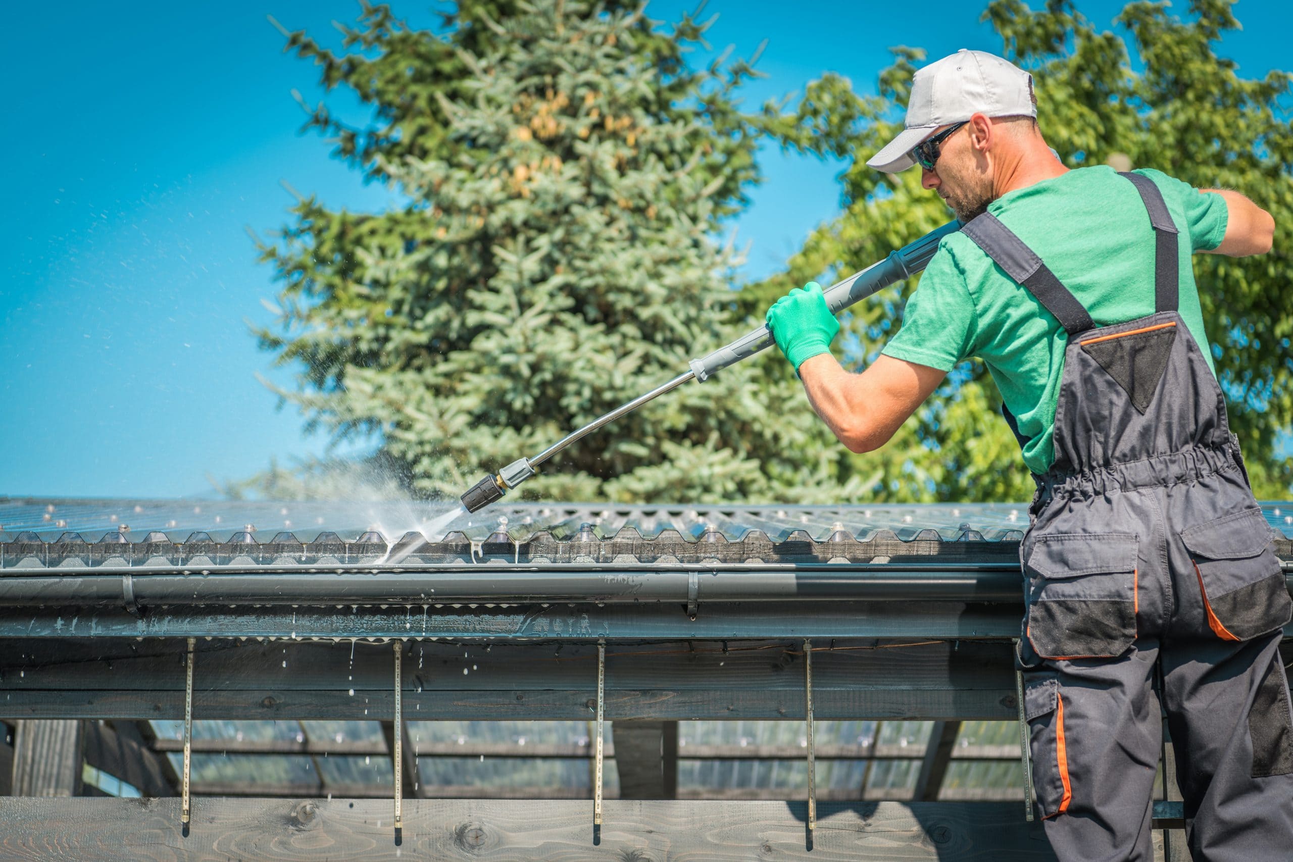 A professional gutter cleaner is cleaning a gutter