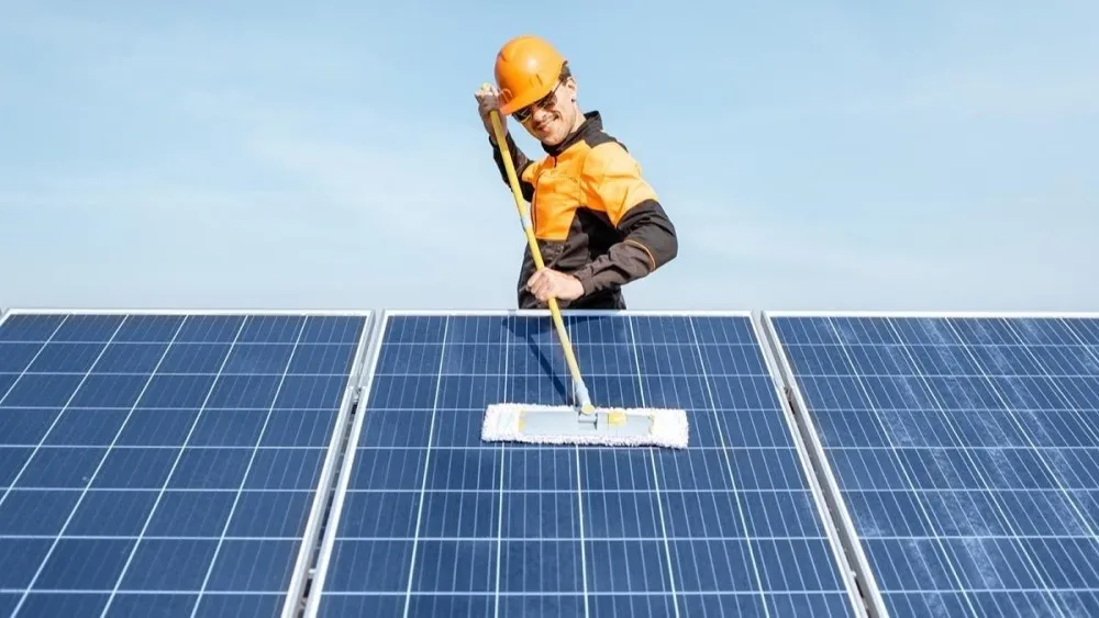 A guy cleaning solar panel